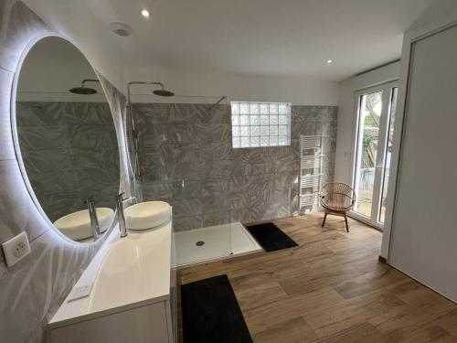 une salle de bain avec un lavabo et un miroir dans l'établissement Charmante villa au coeur du Cap Ferret, à Lège-Cap-Ferret