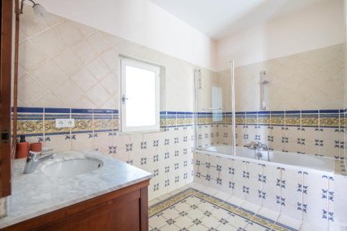 La salle de bains est pourvue d'un lavabo, d'une baignoire et d'une fenêtre. dans l'établissement Mas provençal 14 personnes - parking privé, au Thor