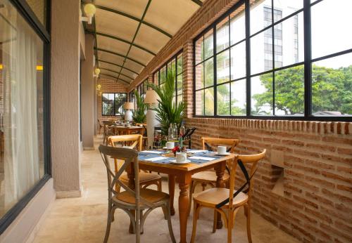 a dining room with a table and chairs and windows at Hotel Caribe by Faranda Grand, a member of Radisson Individuals in Cartagena de Indias