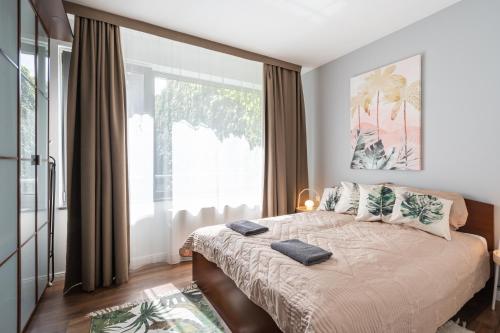 a bedroom with a bed and a large window at City Center Wellness Suites - POOL-GYM-PARKING in Budapest
