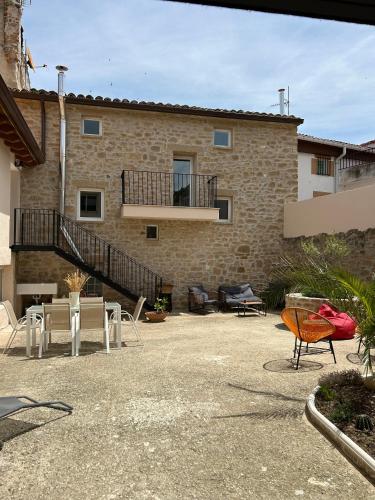 a building with a patio with chairs and a balcony at Enara-enea in Morentin