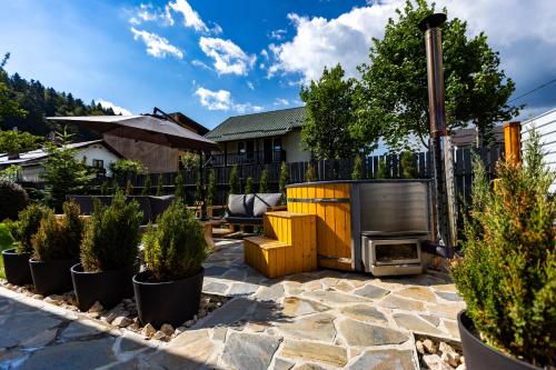 a patio with a fireplace and some potted plants at The Bear Chalet with Private Hot Tub in Buşteni