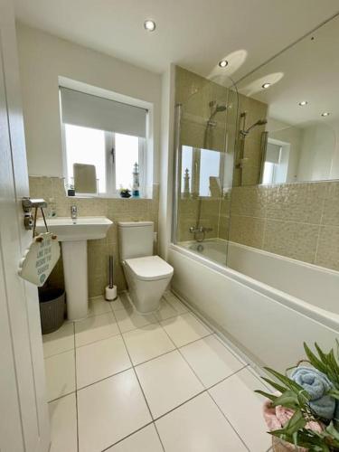 a bathroom with a toilet and a sink and a shower at Stunning Beachfront House in Felixstowe