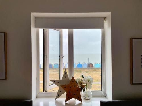 a window with a vase of flowers and a star at Stunning Beachfront House in Felixstowe