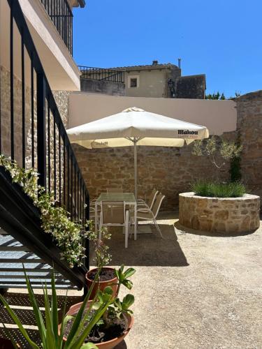 a patio with an umbrella and a table and chairs at Enara-enea in Morentin