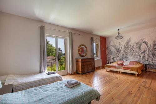 une chambre avec deux lits et une grande fenêtre dans l'établissement Mas provençal 14 personnes - parking privé, au Thor