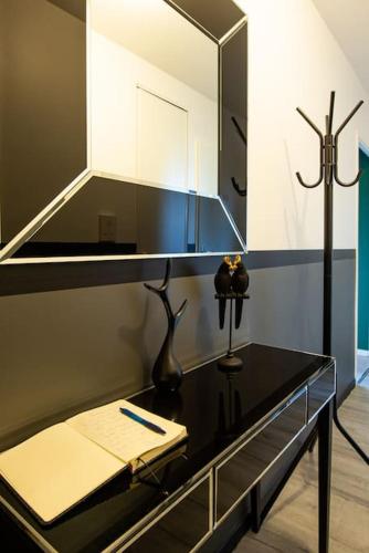 La salle de bains est pourvue d'un miroir et d'une table noire. dans l'établissement Amour & Romance l Jacuzzi XXL l Table de massage, à Vigneux-sur-Seine