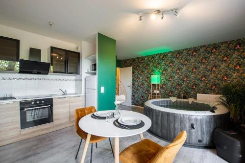 - une cuisine avec une table et une baignoire dans la chambre dans l'établissement Amour & Romance l Jacuzzi XXL l Table de massage, à Vigneux-sur-Seine