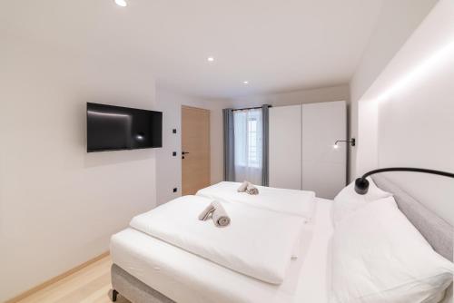 a white bedroom with two white towels on a bed at Rock Salzburg in Salzburg