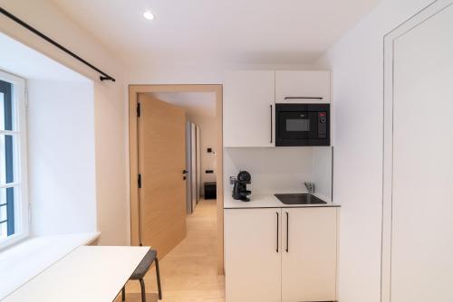a kitchen with white cabinets and a counter top at Rock Salzburg in Salzburg