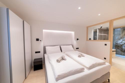 a bedroom with a white bed with slippers on it at Rock Salzburg in Salzburg