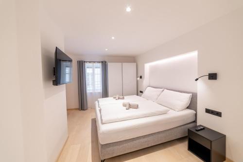 a bedroom with a white bed and a television at Rock Salzburg in Salzburg