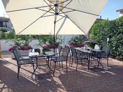 a table and chairs under an umbrella on a patio at Villa Marelago Guest House in Lido Di Fondi