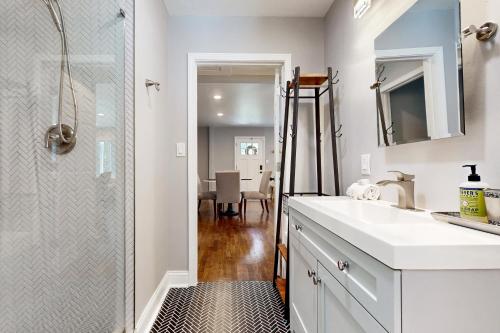a white bathroom with a shower and a sink at Poolside Paradise in South Haven
