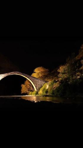 a bridge over a body of water at night at Mountain Harmony Home in Konitsa