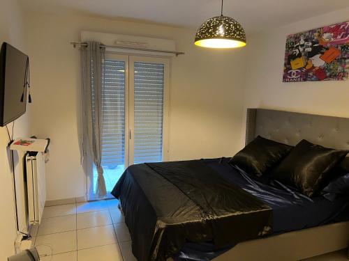 une chambre avec un lit, une télévision et une fenêtre dans l'établissement Appartement tout confort, à Nice