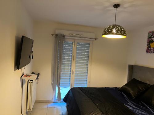 une chambre avec un lit, une télévision et une fenêtre dans l'établissement Appartement tout confort, à Nice