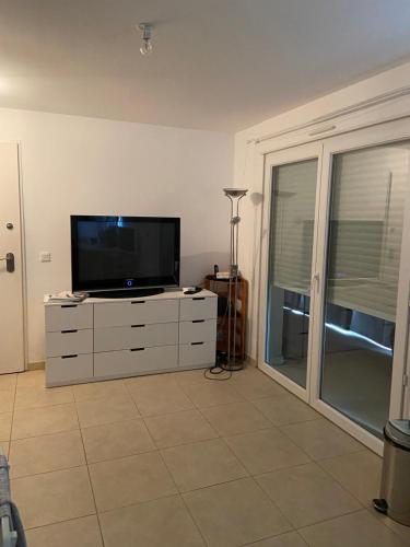 - un salon avec une commode et une télévision à écran plat dans l'établissement Location mer les sablettes chez Huguette, à La Seyne-sur-Mer