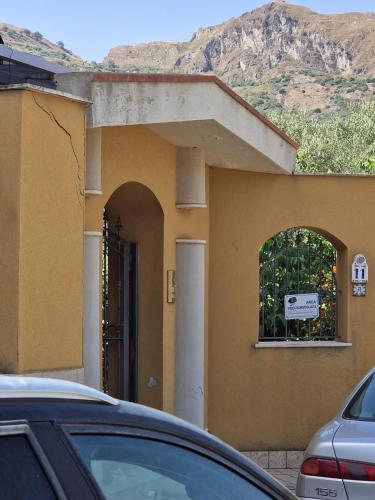 a house with a window and a car parked in front at Villa Mary Sol in Savoca 