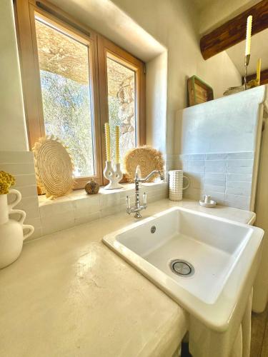 une salle de bain avec un lavabo blanc et une fenêtre dans l'établissement La Casa D'Ange Bergerie de Luxe Piscine chauffée, à Lama