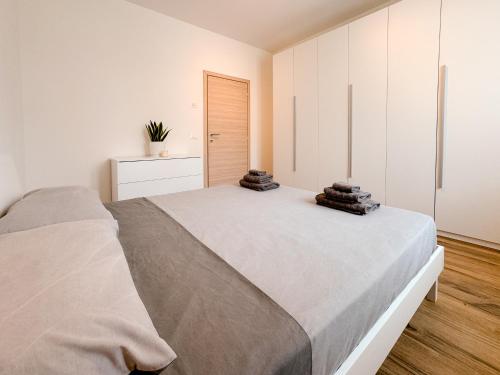 a bedroom with a large bed and white cabinets at Lake View Levico in Levico Terme