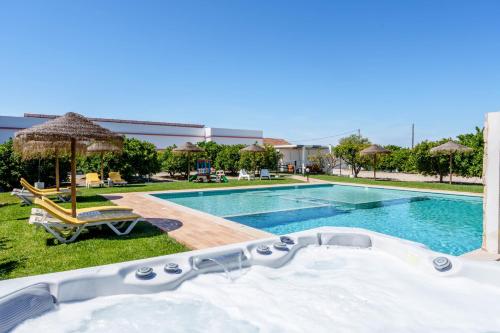 a swimming pool with a jacuzzi and a tub at Quinta dos Is in Algoz