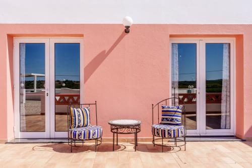 two chairs and a table on a patio at Quinta dos Is in Algoz