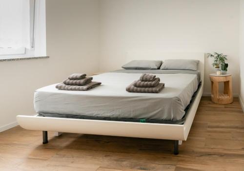 a bed with two brown towels on top of it at Lake View Levico in Levico Terme