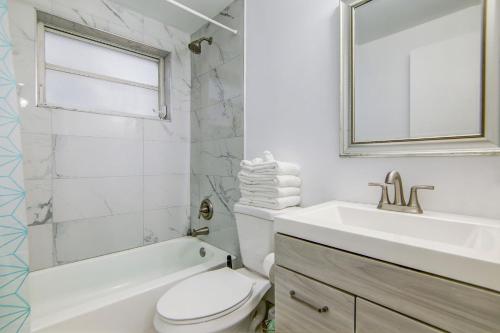 Un baño blanco con lavabo e inodoro. en Balcony Deco Apt, w/2 QueenBeds, on Ocean Dr Beach, en Miami Beach