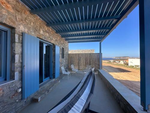 a patio with a bench and a table and chairs at Filotimia in Skhoinoussa