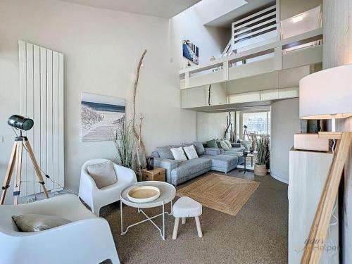 un salon avec un canapé et une table dans l'établissement Le Belvédère YourHostHelper, à Deauville