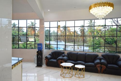 a living room with a couch and a large window at M Grand Stay in Coimbatore