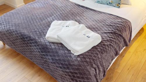 a bed with two white towels on top of it at Le 44 - Maison familiale - Grand confort - 700m Plages in Dinard