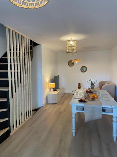 un salon avec une table bleue et un escalier dans l'établissement Appartement Cosy Centre-Ville avec Terrasse, à Saint-Didier