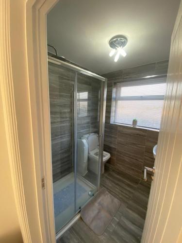 a bathroom with a shower and a toilet in it at Beach way in Prestatyn