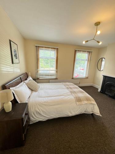 a bedroom with a large bed and a fireplace at Shine Lodge in Kent