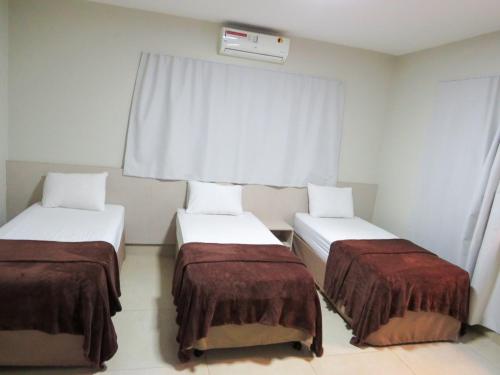 a room with two beds and a window at Sudoeste Hotel in Goiânia