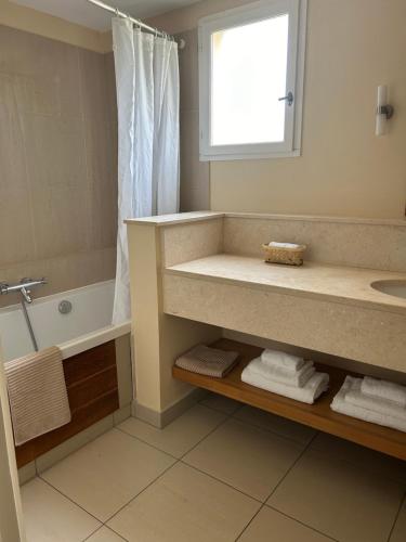 La salle de bains est pourvue d'un lavabo, d'une baignoire et d'une fenêtre. dans l'établissement Suite Supérieure 40 m2 Domaine du Golf St Endreol, 1 à 4 personnes, à La Motte