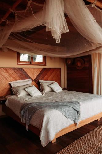 a bedroom with a canopy bed with white pillows at AguaMar Vichayito in Los Órganos