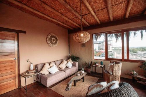 a living room with a couch and some windows at AguaMar Vichayito in Los Órganos