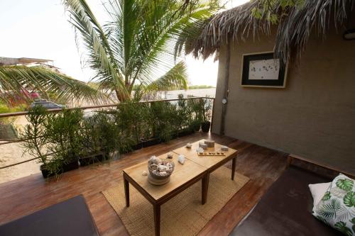 a patio with a table and a balcony with palm trees at AguaMar Vichayito in Los Órganos
