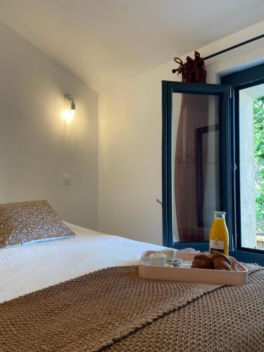 - un plateau de pain et de jus d'orange sur le lit dans l'établissement Appartement Cosy Centre-Ville avec Terrasse, à Saint-Didier