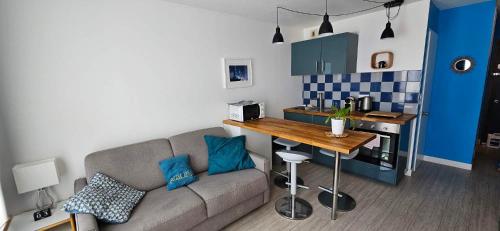 ein Wohnzimmer mit Couch und Küche in der Unterkunft Studio Victoria Centre Grande Plage and Pool in Biarritz