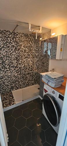 une cuisine avec un lave-linge et un mur en carrelage dans l'établissement Studio Victoria Centre Grande Plage and Pool, à Biarritz