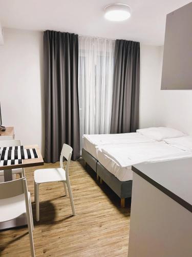a hotel room with two beds and a table and chair at Apartamenty Villa Baltica Rewal - jacuzzi na dachu, wi-fi, parking w cenie in Rewal