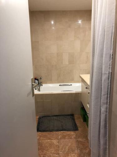 une salle de bain avec un lavabo et une baignoire dans l'établissement Appartement cosy et calme - au cœur de Levallois - avec balcon, à Levallois-Perret