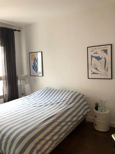 - une chambre avec un lit rayé bleu et blanc dans l'établissement Appartement cosy et calme - au cœur de Levallois - avec balcon, à Levallois-Perret
