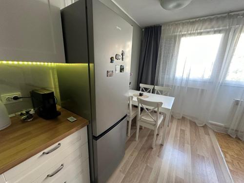 a kitchen with a refrigerator and a table with a window at M&M Herc in Velika Gorica