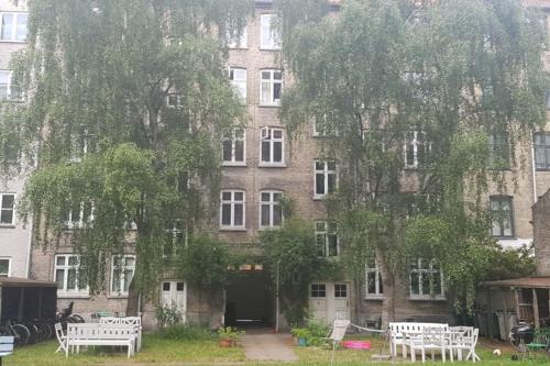 a large brick building with white benches in front of it at I hjertet af København nær Marmorkirken Metro in Copenhagen