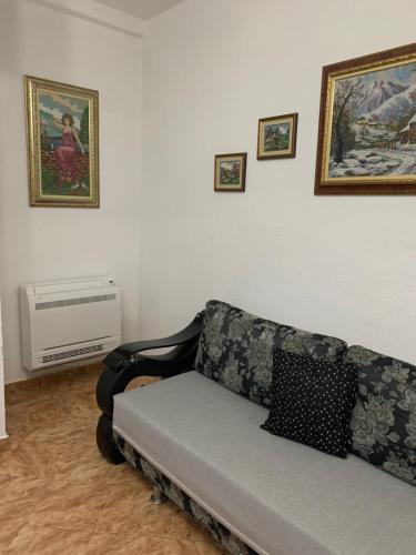a couch in a living room with pictures on the wall at Fabio's Apartament in Pogradec